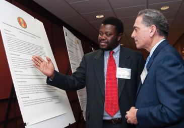 two colleagues discussing symposium poster